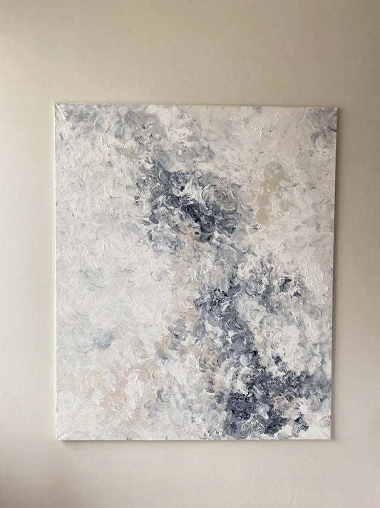 Abstract art painting with gray, blue, and beige tones on a beige wall.